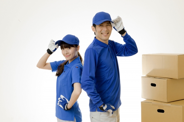 引っ越し業者の男性と女性と段ボール