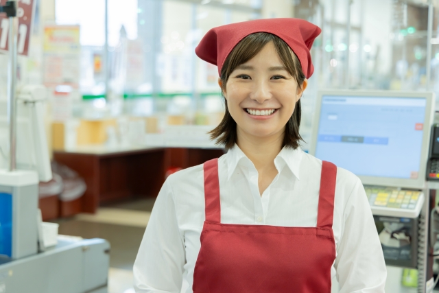 スーパーマーケットのレジにいる笑顔の女性