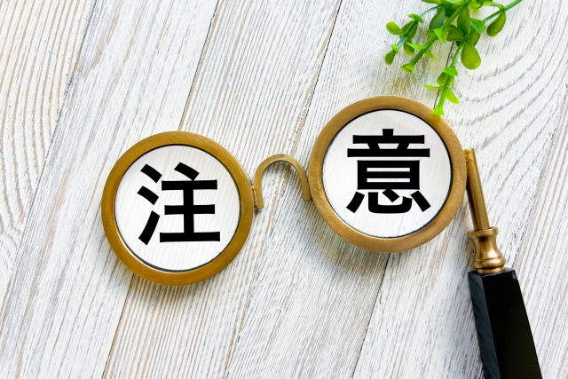 注意と書いた文字を虫眼鏡で見ている